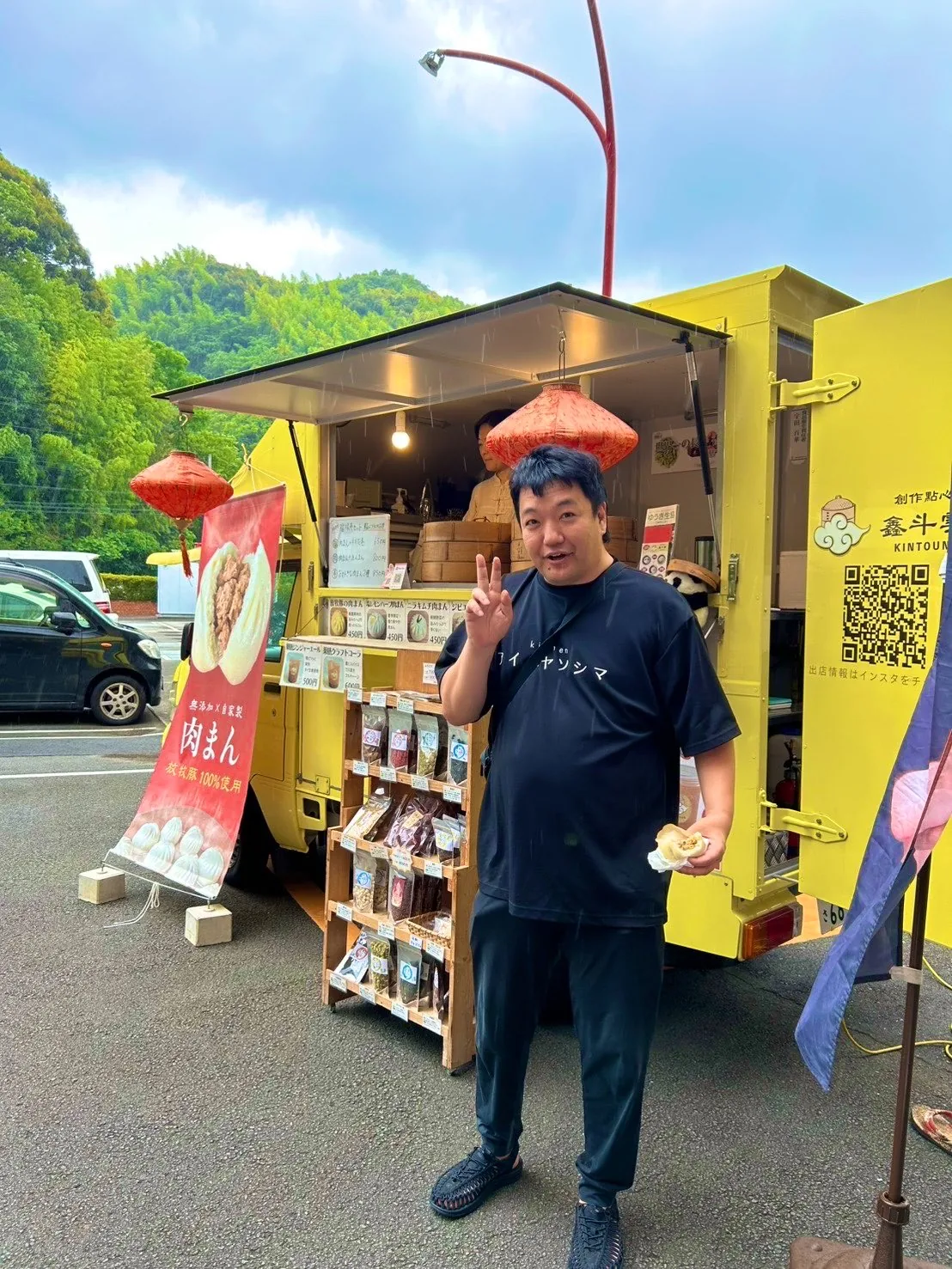 肉まんのキッチンカーで商品を手にする八十島