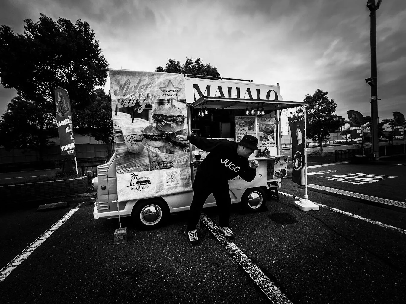 ハンバーガーのキッチンカー前でポーズを取る八十島